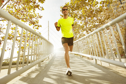 young man running across a bridge